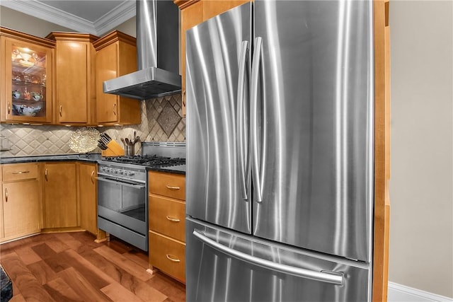 kitchen with dark wood-style flooring, decorative backsplash, appliances with stainless steel finishes, crown molding, and wall chimney range hood