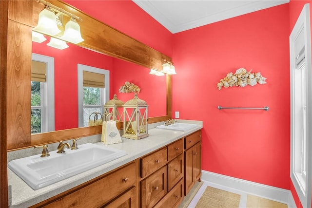 bathroom featuring double vanity, crown molding, baseboards, and a sink