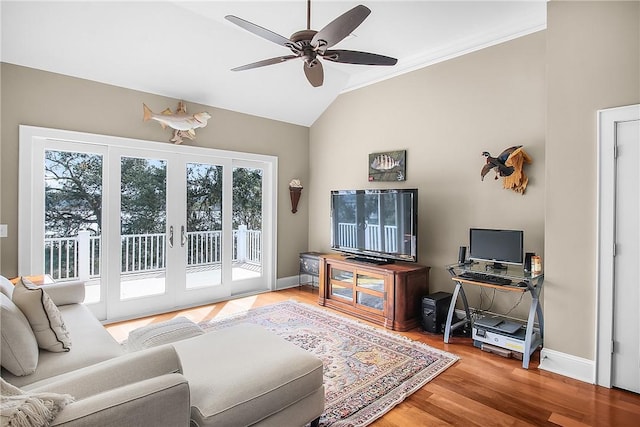 living area with baseboards, wood finished floors, a ceiling fan, and vaulted ceiling