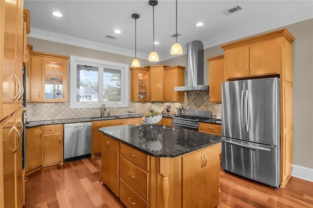 kitchen featuring visible vents, appliances with stainless steel finishes, wall chimney exhaust hood, and a sink