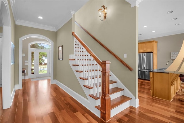 entrance foyer with ornamental molding, wood finished floors, recessed lighting, baseboards, and stairs