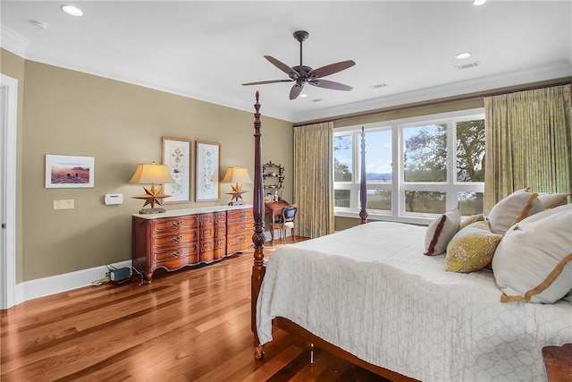 bedroom with visible vents, ornamental molding, wood finished floors, recessed lighting, and baseboards