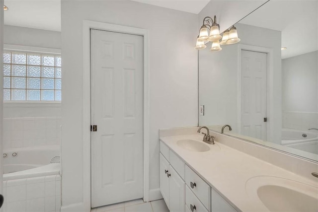 bathroom with tile patterned flooring, vanity, and tiled tub