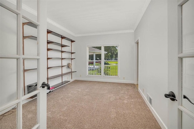 carpeted empty room with crown molding and french doors