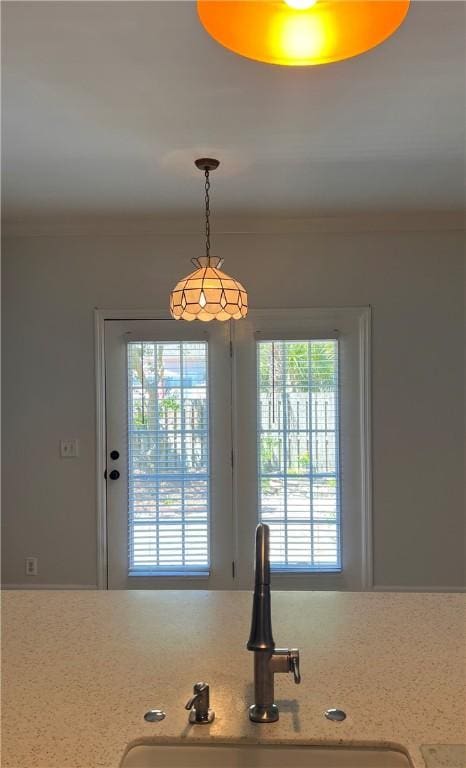 interior space featuring crown molding, sink, and decorative light fixtures