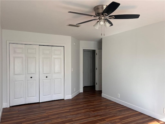 unfurnished bedroom with ceiling fan, dark hardwood / wood-style flooring, and a closet