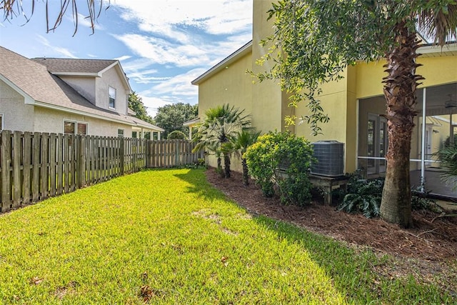 view of yard with a sunroom and central air condition unit