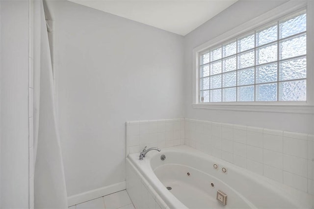 bathroom with tiled tub and tile patterned flooring