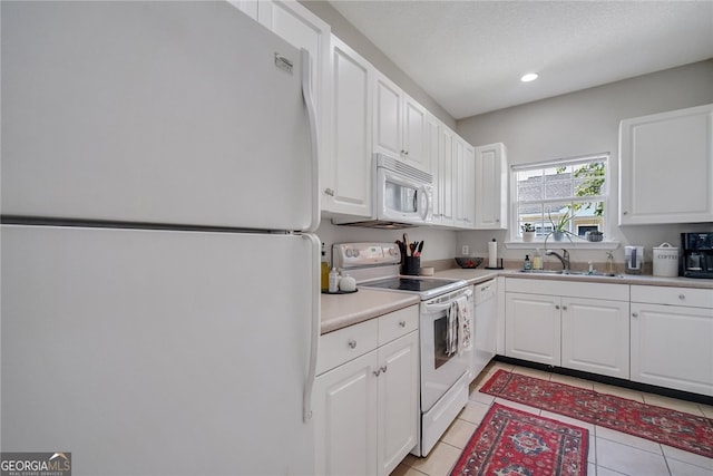 348 Moss Creek Ln, Brunswick, GA 31522 - kitchen featuring white appliances, white cabinets, light tile patterned floors, light countertops, and recessed lighting