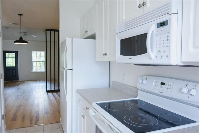 348 Moss Creek Ln, Brunswick, GA 31522 - kitchen featuring white appliances, light countertops, white cabinetry, hanging light fixtures, and light wood-style floors