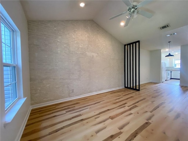 348 Moss Creek Ln, Brunswick, GA 31522 - unfurnished living room with brick wall, light wood-style flooring, ceiling fan, and vaulted ceiling