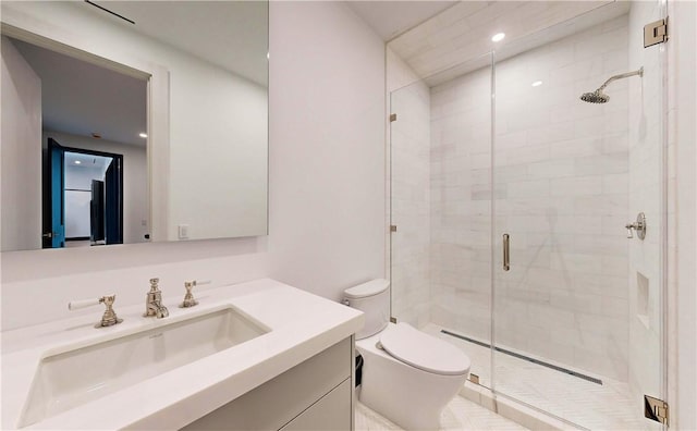 bathroom featuring vanity, toilet, and a shower with shower door