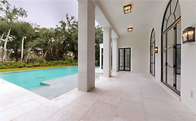 view of swimming pool featuring a patio area and french doors