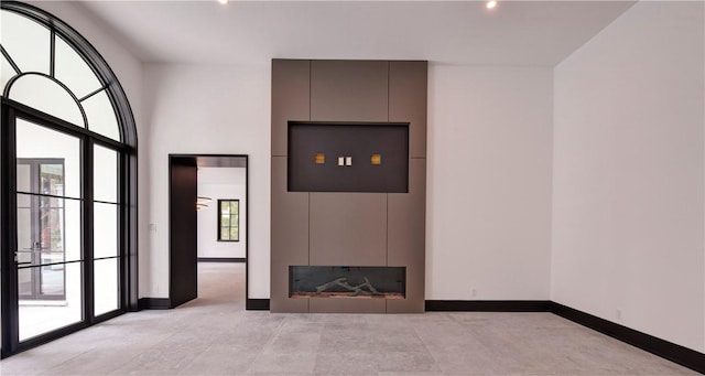 unfurnished living room featuring a large fireplace and a healthy amount of sunlight