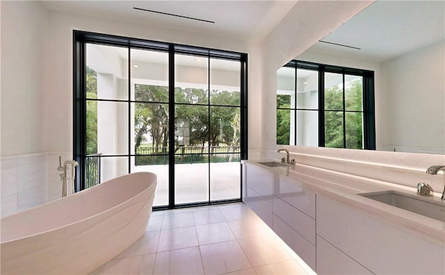 doorway to outside featuring light tile patterned floors, a wealth of natural light, and sink