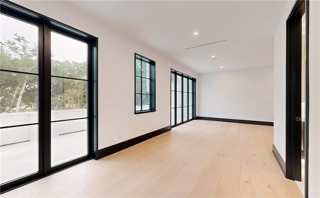 empty room featuring plenty of natural light and light hardwood / wood-style flooring