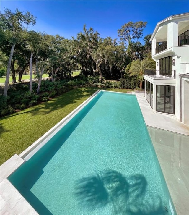 view of swimming pool featuring a yard