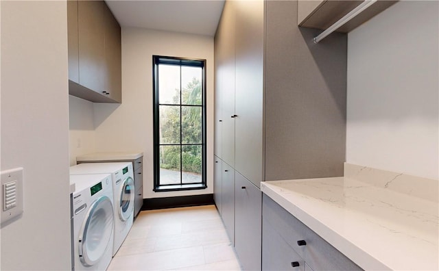 laundry area featuring washer and clothes dryer and cabinets