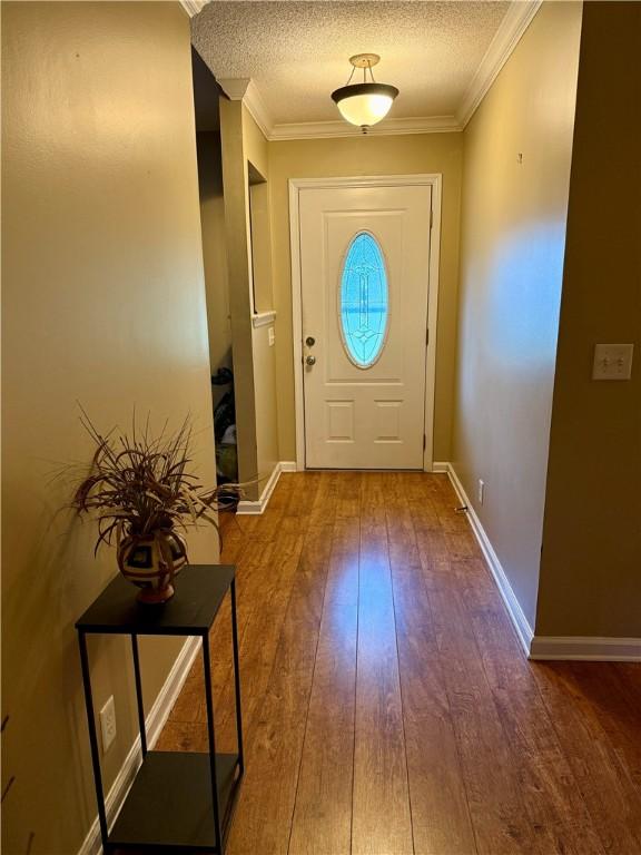 101 Brighton Cir, Brunswick, GA 31525 - doorway to outside featuring wood-type flooring, crown molding, and a textured ceiling