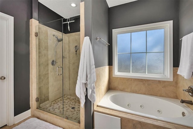 bathroom featuring a jetted tub and a shower stall