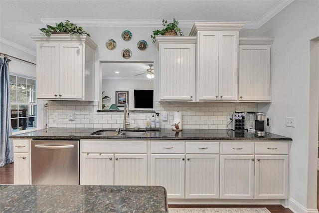 kitchen featuring dark stone countertops, white cabinetry, ornamental molding, a sink, and stainless steel dishwasher