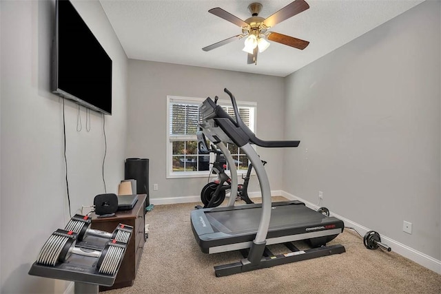 exercise room with a textured ceiling, carpet flooring, baseboards, and ceiling fan