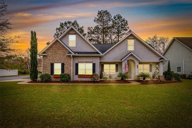 traditional-style home with brick siding and a yard