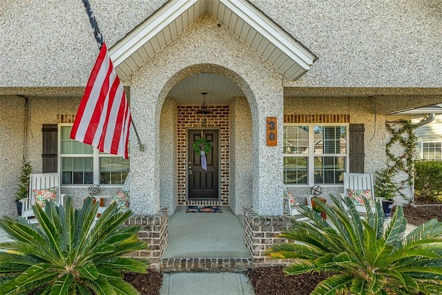 property entrance featuring stucco siding and a porch