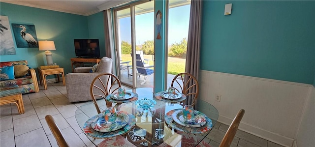 dining space featuring crown molding and light tile patterned floors