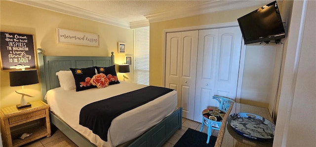 bedroom with ornamental molding, light tile patterned floors, a textured ceiling, and a closet