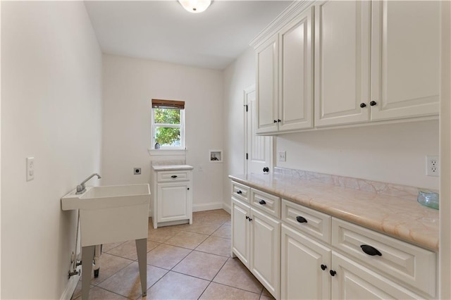 114 Wedge Wood Ct, Brunswick, GA 31525 - laundry area featuring cabinet space, electric dryer hookup, washer hookup, light tile patterned floors, and baseboards