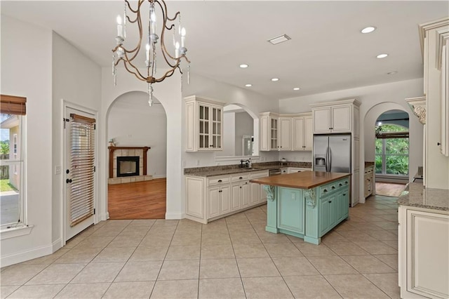 114 Wedge Wood Ct, Brunswick, GA 31525 - kitchen with arched walkways, butcher block counters, a fireplace, built in refrigerator, and light tile patterned floors
