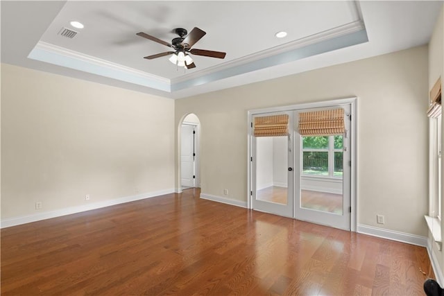 114 Wedge Wood Ct, Brunswick, GA 31525 - spare room with a raised ceiling, a ceiling fan, arched walkways, wood finished floors, and crown molding