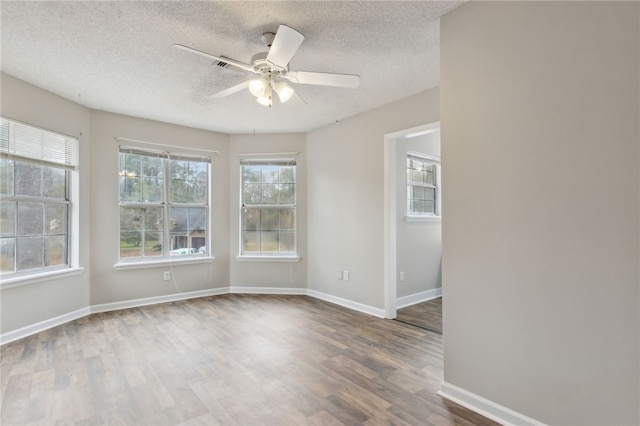 spare room featuring ceiling fan, dark wood-type flooring, and a textured ceiling