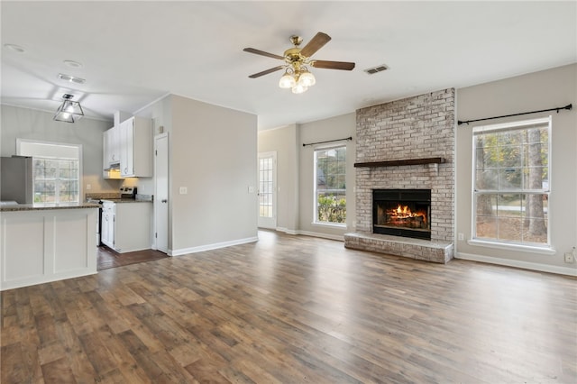 unfurnished living room with a fireplace, dark hardwood / wood-style flooring, and ceiling fan