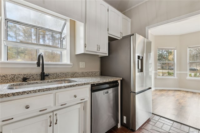 kitchen featuring light stone countertops, sink, white cabinetry, and stainless steel appliances