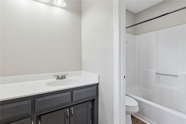 full bathroom with washtub / shower combination, hardwood / wood-style floors, vanity, and toilet