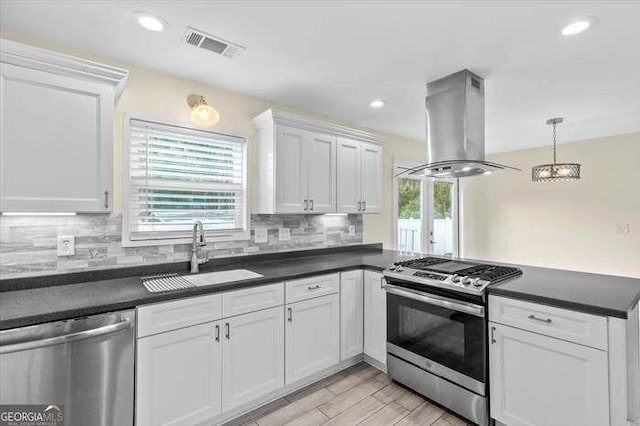 kitchen featuring white cabinets, hanging light fixtures, sink, appliances with stainless steel finishes, and island range hood