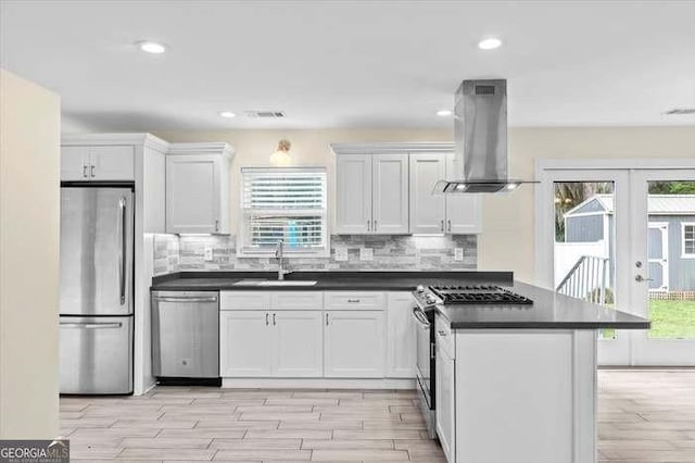 kitchen with white cabinets, ventilation hood, stainless steel appliances, and sink