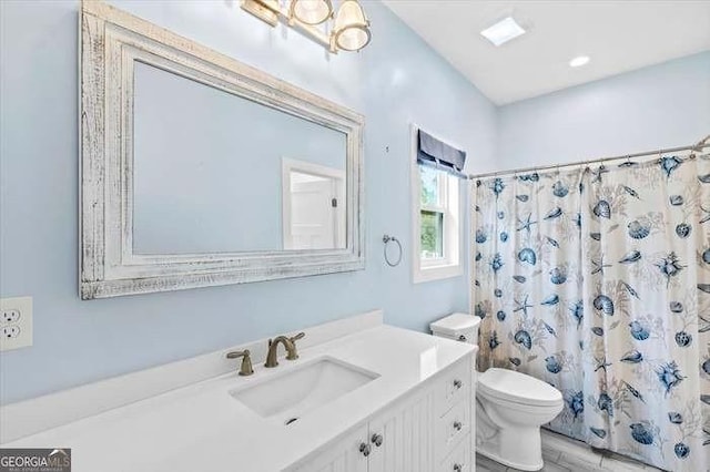 bathroom with a shower with shower curtain, vanity, and toilet