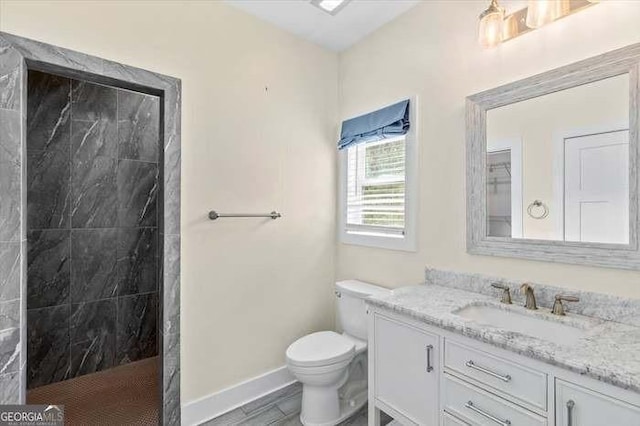 bathroom featuring toilet, vanity, and tiled shower