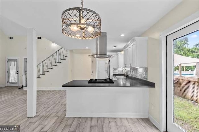 kitchen with island exhaust hood, pendant lighting, white cabinetry, and plenty of natural light