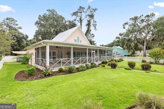 rear view of property featuring a sunroom and a yard