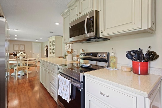 314 King David Rd, Jesup, GA 31545 - kitchen with stainless steel appliances, wood finished floors, recessed lighting, light stone countertops, and glass insert cabinets