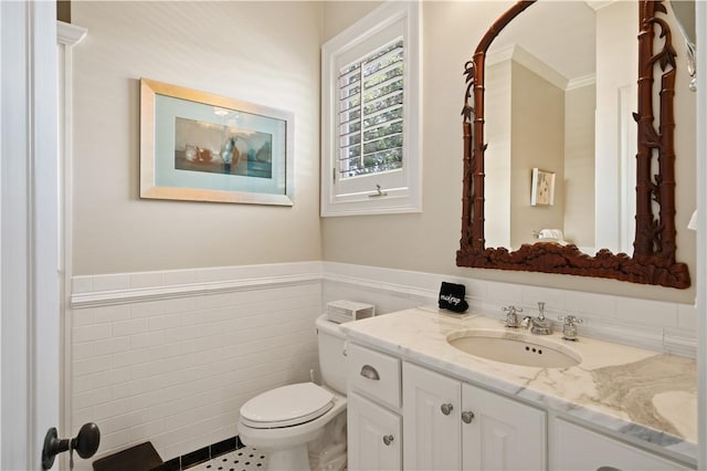 bathroom featuring tile patterned floors, vanity, tile walls, and toilet