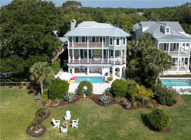 back of house with a yard, a patio, and a balcony