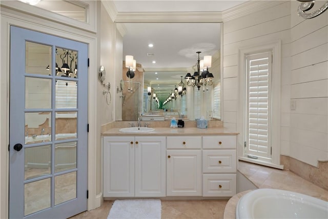 bathroom with a tub, a notable chandelier, tile patterned floors, crown molding, and vanity