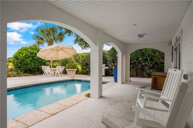 view of pool with a patio area and a grill