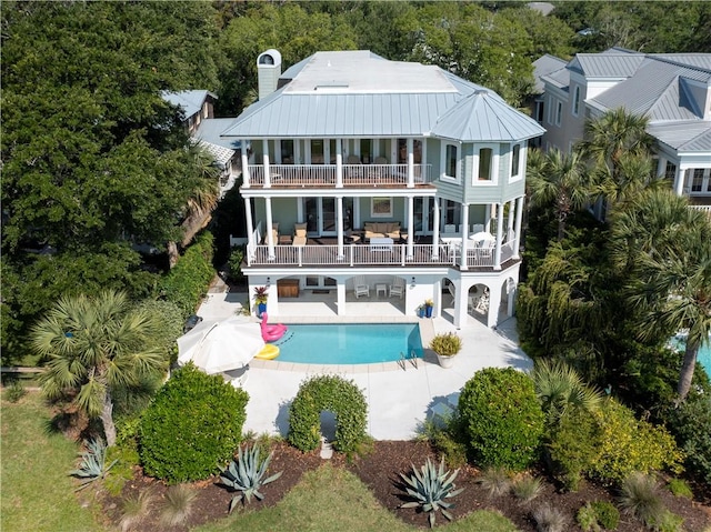 back of property featuring a patio area, outdoor lounge area, and a balcony