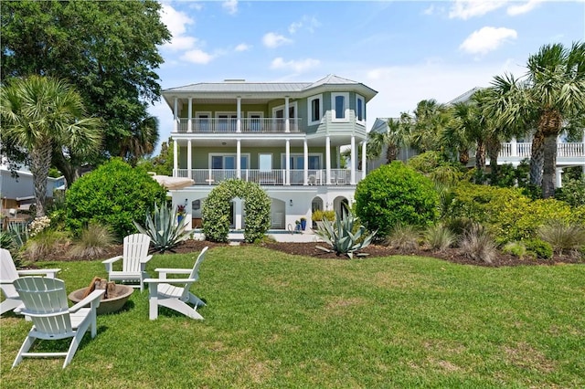 back of property with a balcony and a yard